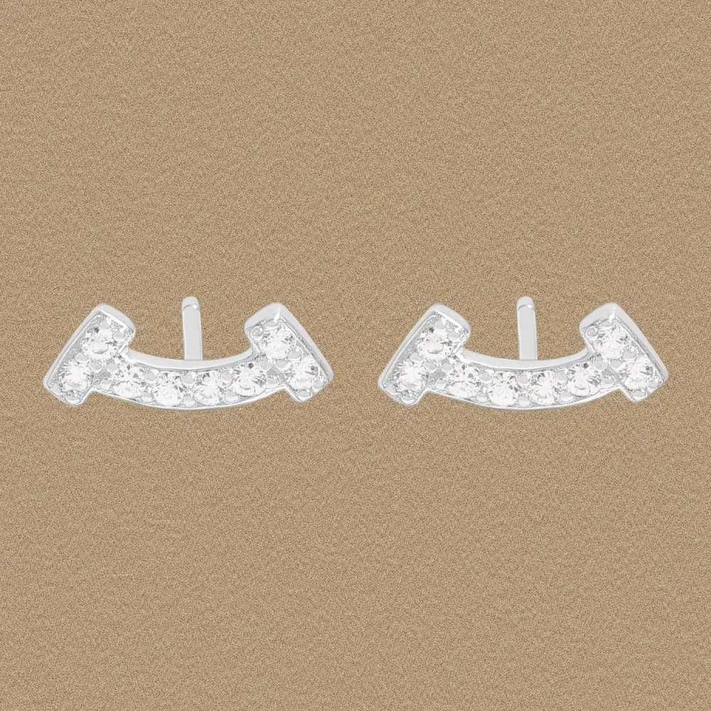 Polished sterling silver curved bar earrings with a row of small stones along the arc, displayed against a gold-toned background.