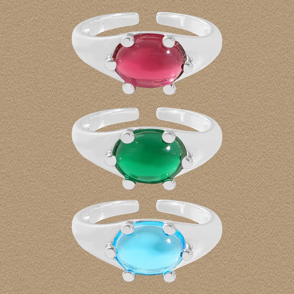 Open-band sterling silver ring with an oval pink, green, or blue cabochon held by four prongs.