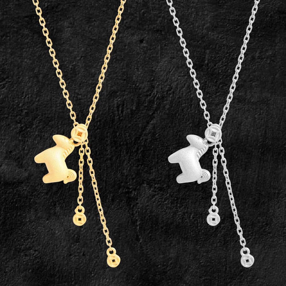 Two-tone cat charm necklace with adjustable chains and dangling bead accents on a dark background.