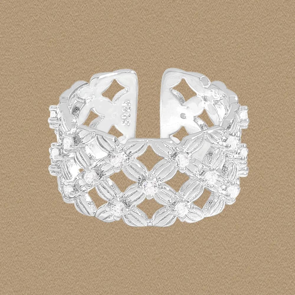 Sterling silver floral lattice ring with openwork petal motifs on a textured background.