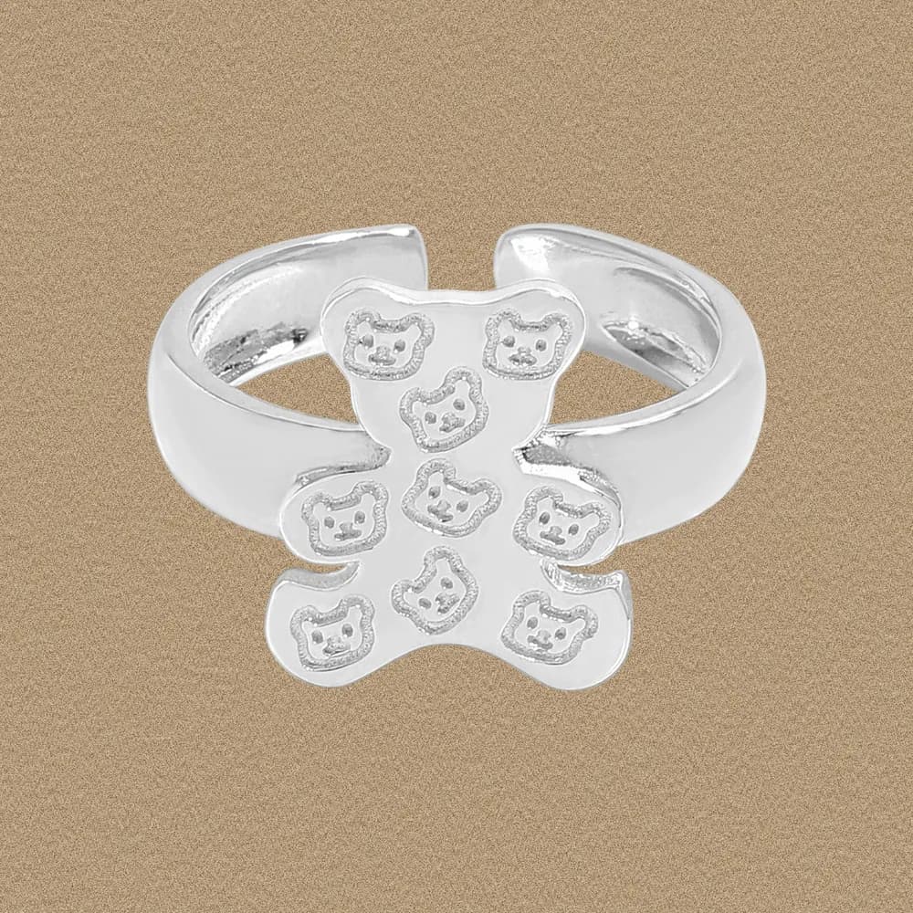 Polished sterling silver ring with a four-lobed bear-face flower centerpiece on a neutral background.