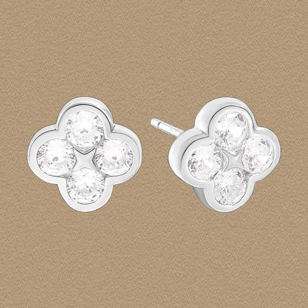 Polished sterling silver four-petal clover stud earrings with crystal-clear stones in each petal.