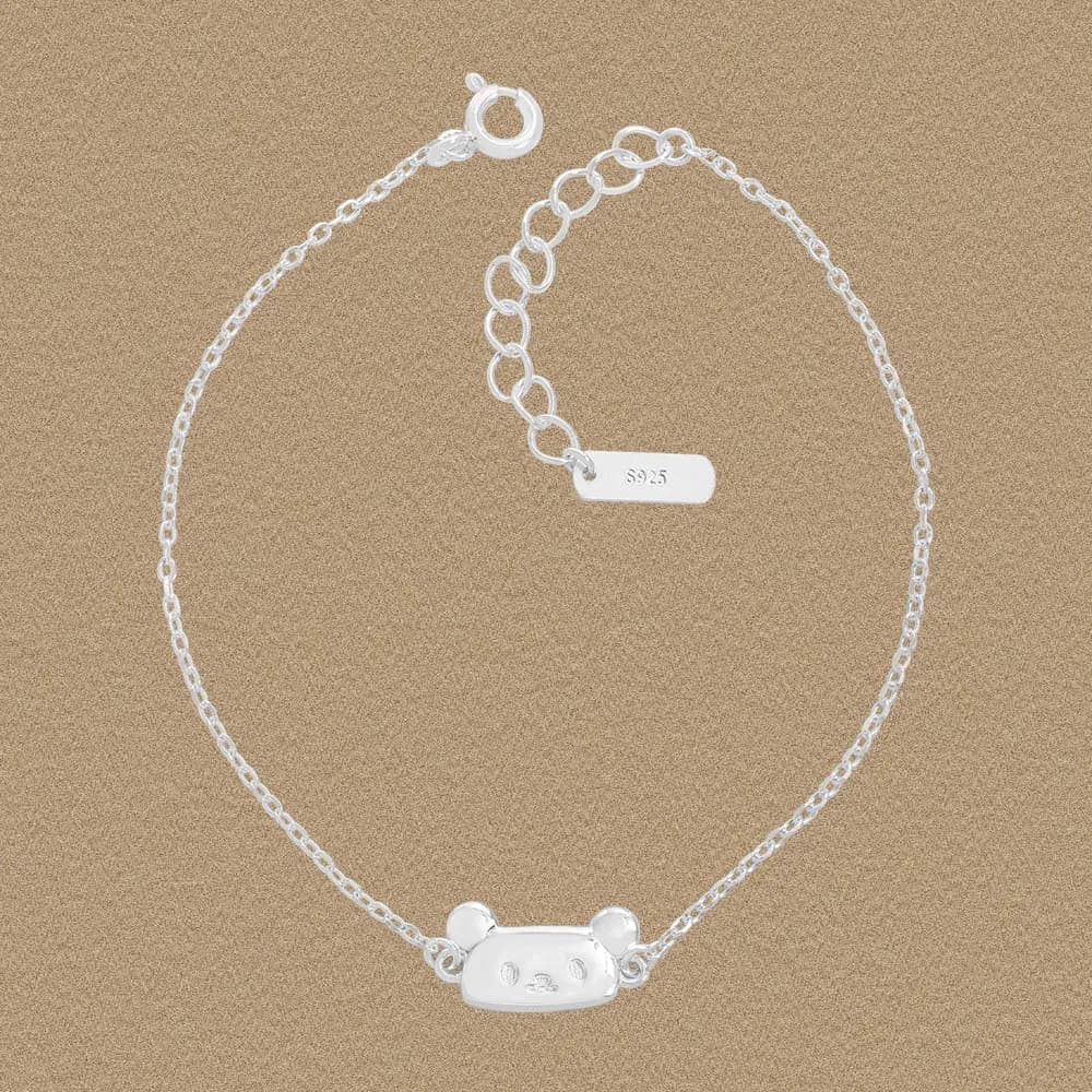 Close-up of a polished sterling silver panda head bar bracelet with a delicate chain and extender.