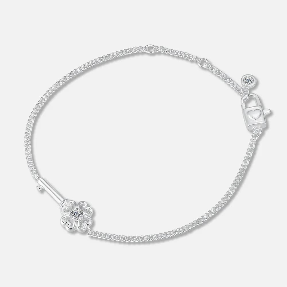 Polished sterling silver bracelet with a flower charm and heart-cutout lock on a light background.