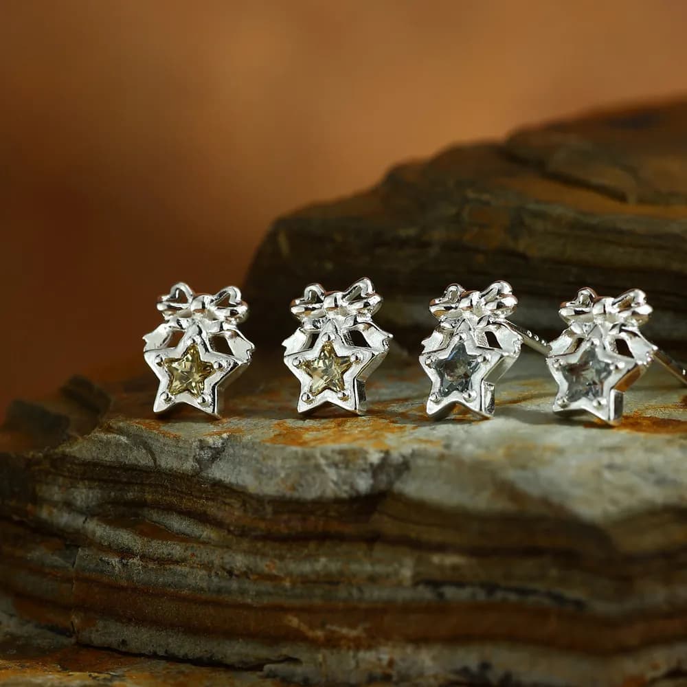Four sterling silver star-cutout stud earrings, each with a small enamel-filled inner star.