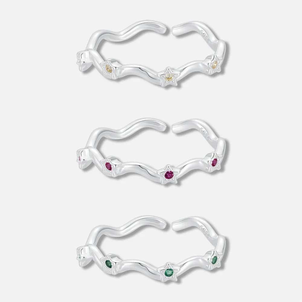 Sterling silver wavy ring with three star settings containing yellow, pink, and green stones.