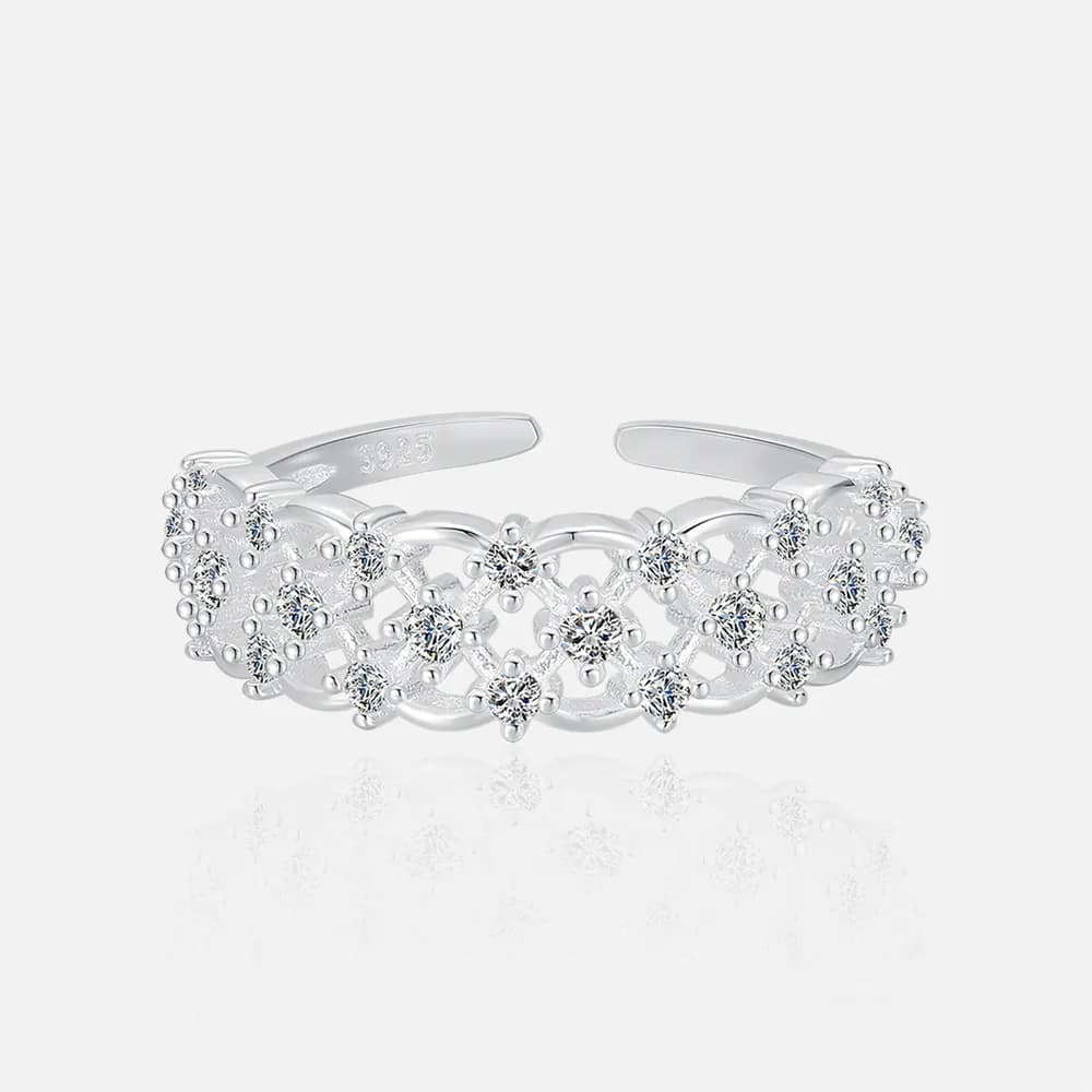 Close-up of a polished sterling silver ring with an open lattice design and small clear stones at each intersection.