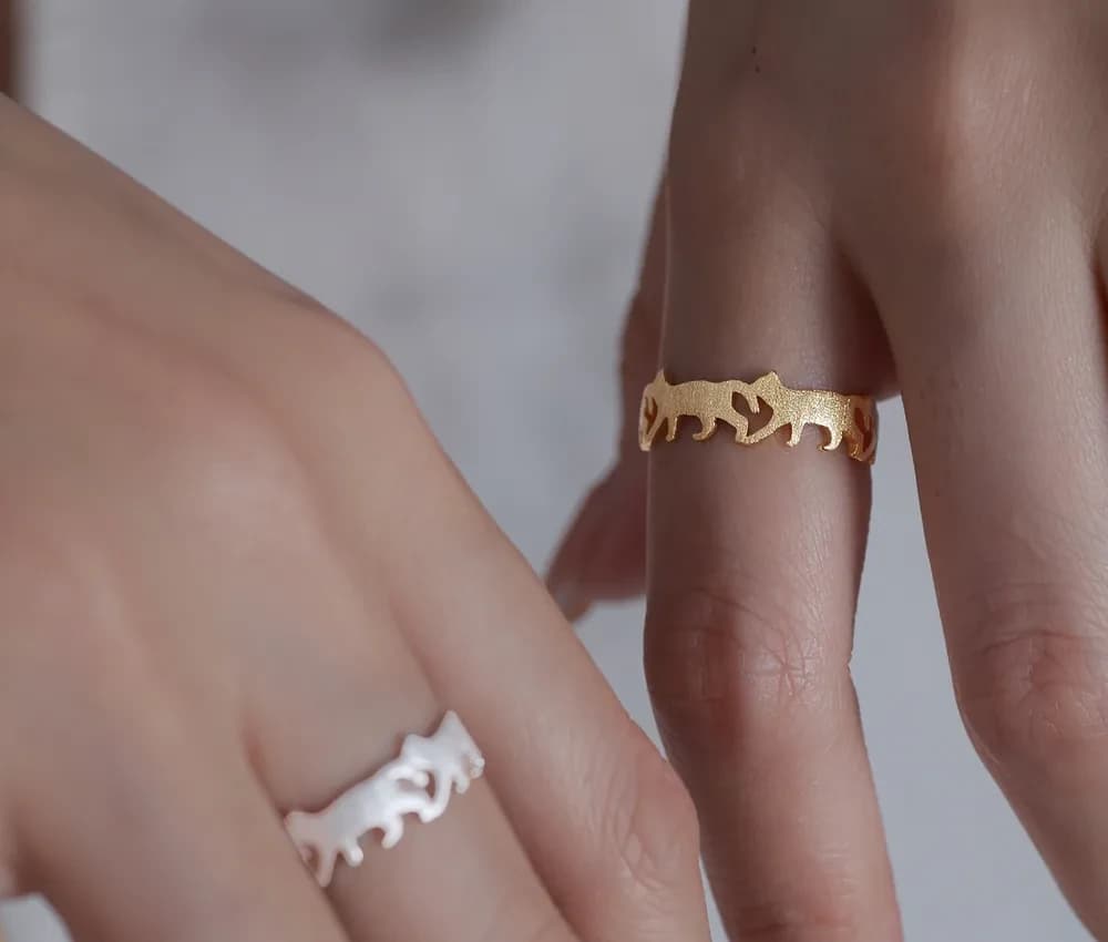 A polished ring with a continuous animal silhouette cutout design around a slim band.