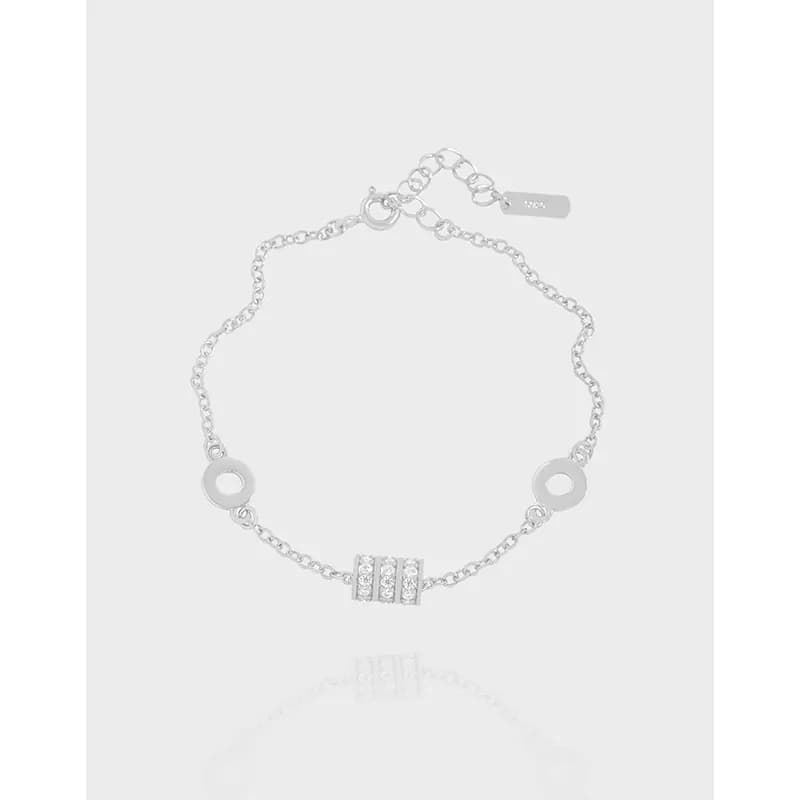 Polished sterling silver bracelet with circle links and a pavé-bar centerpiece on a light background.