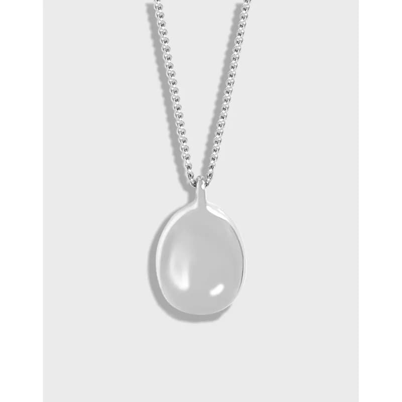 Sterling silver ball-chain necklace with a teardrop pearl pendant on a light background.
