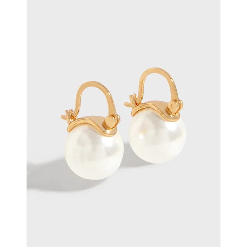 Polished sterling silver earrings with curved gold-tone arch and white pearl drops.
