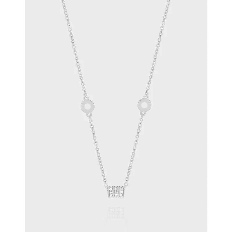 Polished sterling silver necklace with hollow circle spacers and pavé bar pendant on a light background.