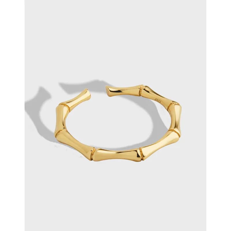 Polished bamboo-segment ring in a warm gold tone on a light background.