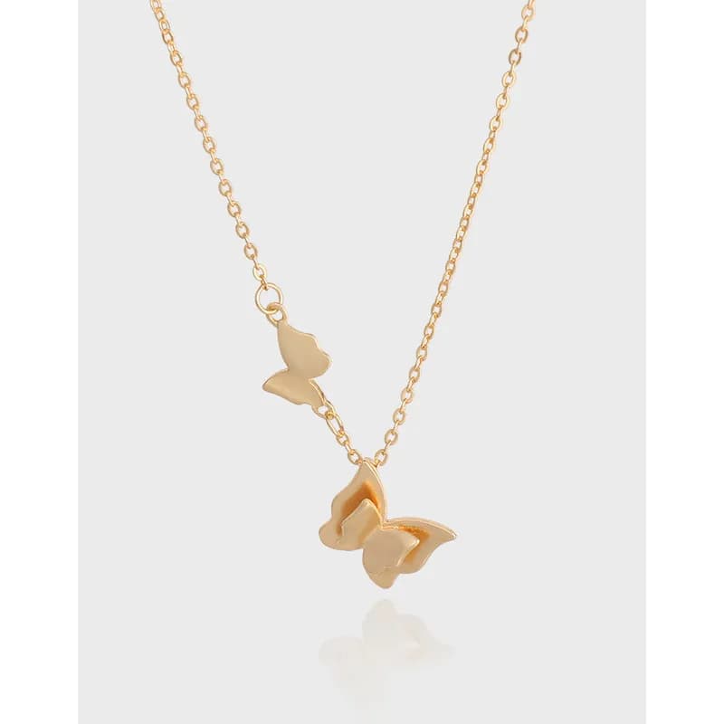 Polished sterling silver butterfly pendant necklace with two charms on a fine chain.