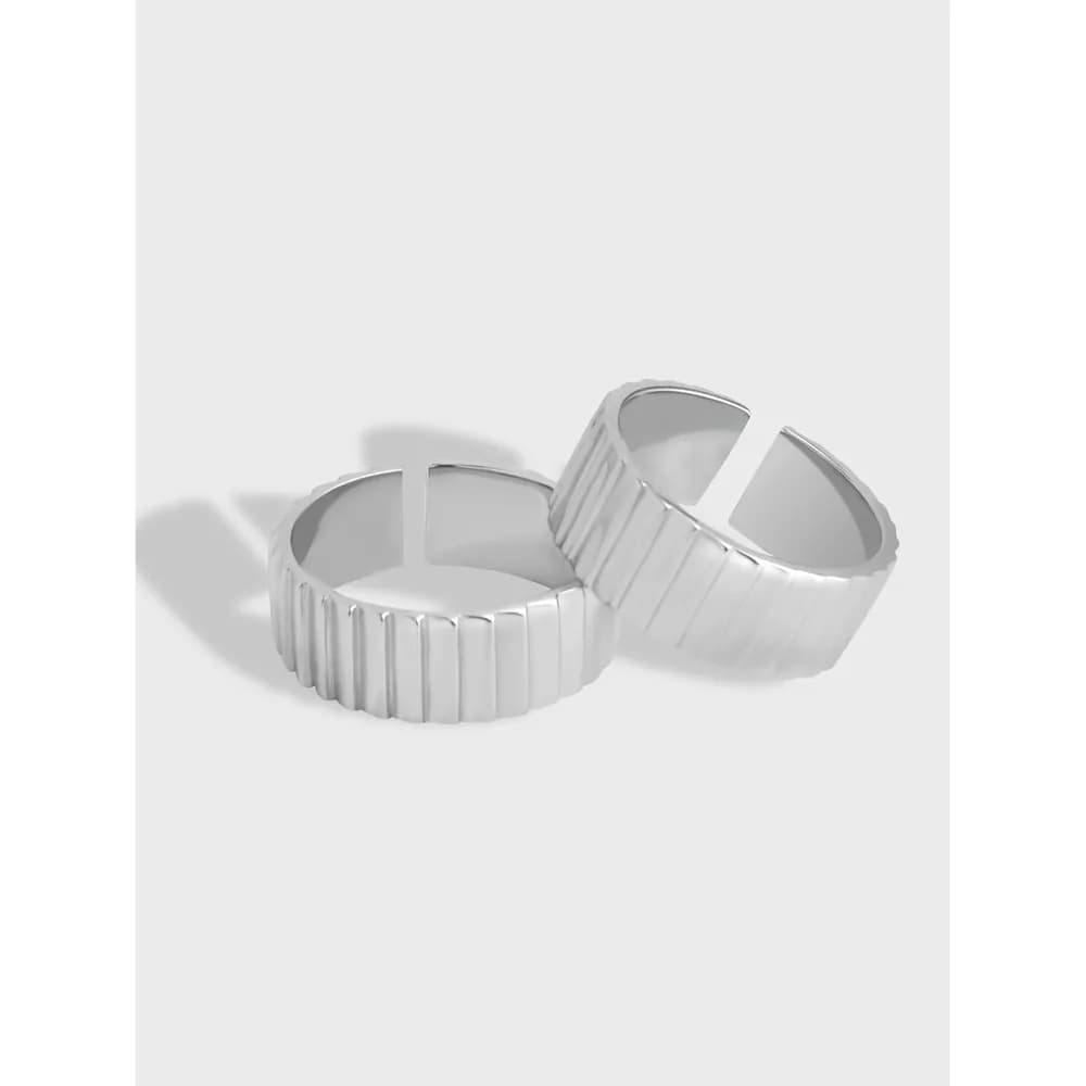 Two polished sterling silver ribbed rings with vertical grooves on a light gray background.