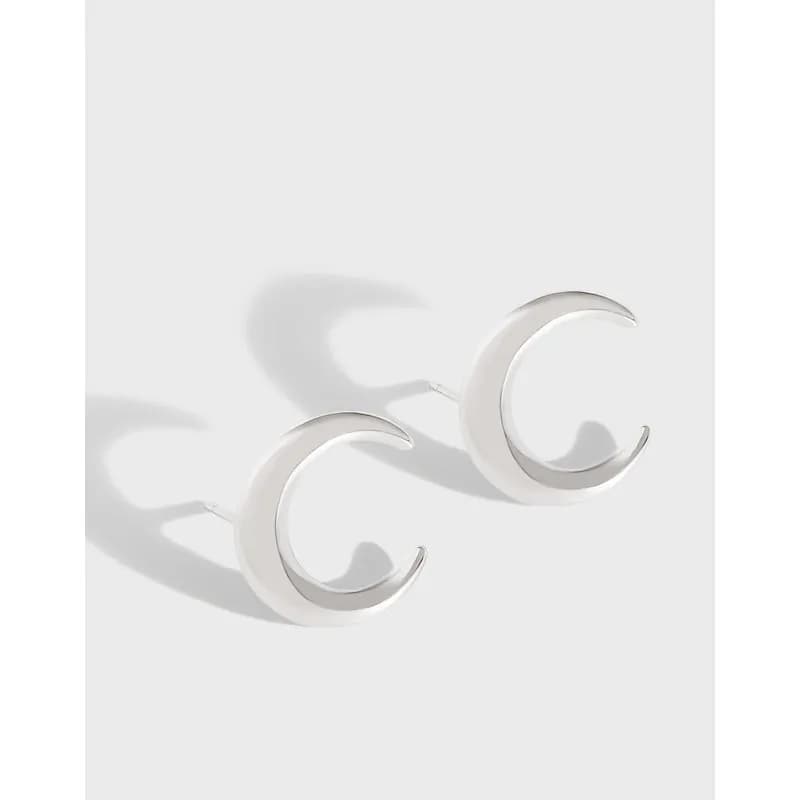 Polished sterling silver crescent hoop earrings on a light background.