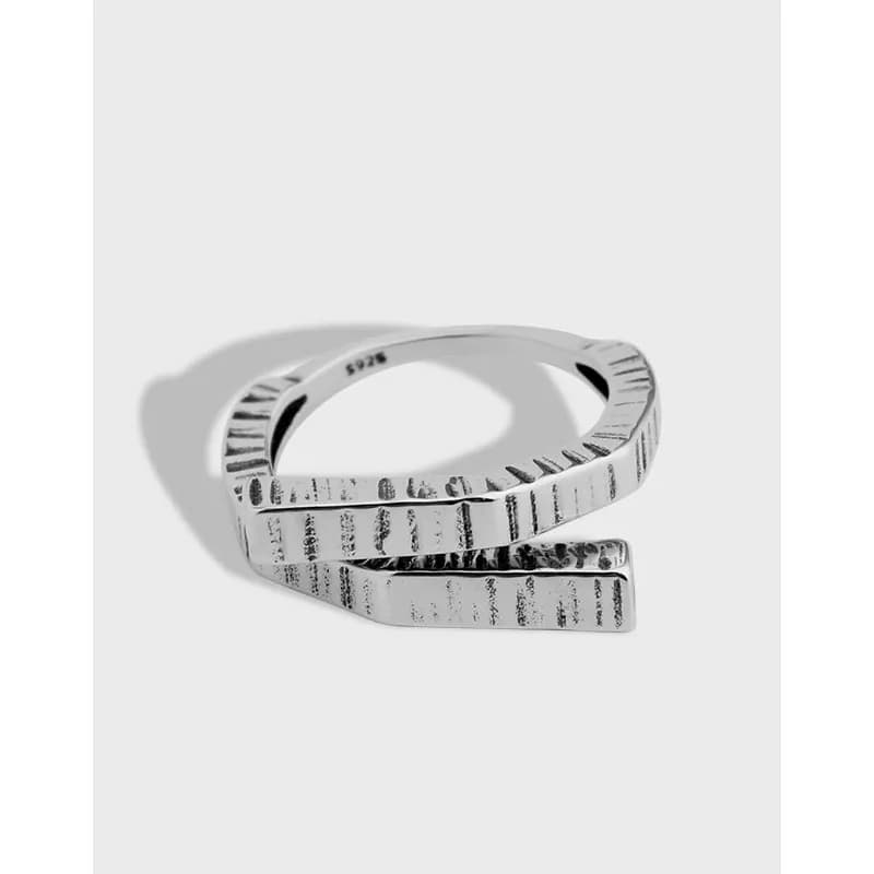 Sterling silver textured wrap ring with striped pattern and open-ended design.