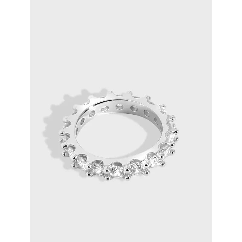 Polished sterling silver pavé diamond ring with a continuous row of stones around the top of the band.