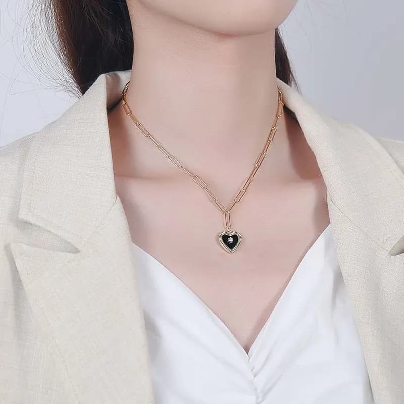 Polished sterling silver heart pendant necklace resting at the model's collarbone
