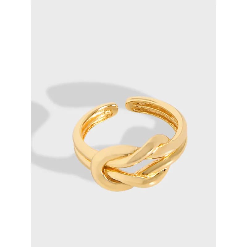 Polished sterling silver knot ring with an intertwined center design on a simple band.