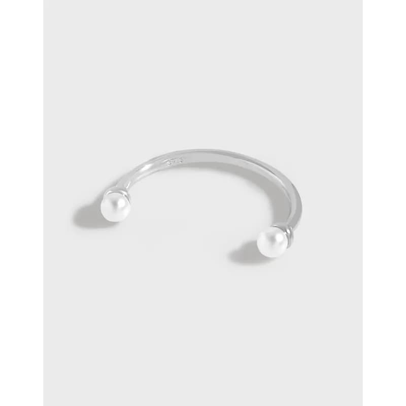 Open sterling silver ring with pearl beads at both ends, photographed against a white background.