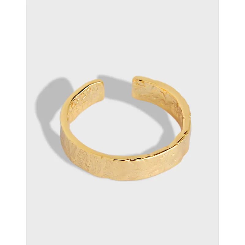 Open, textured hammered ring in a warm gold-tone on a light background.