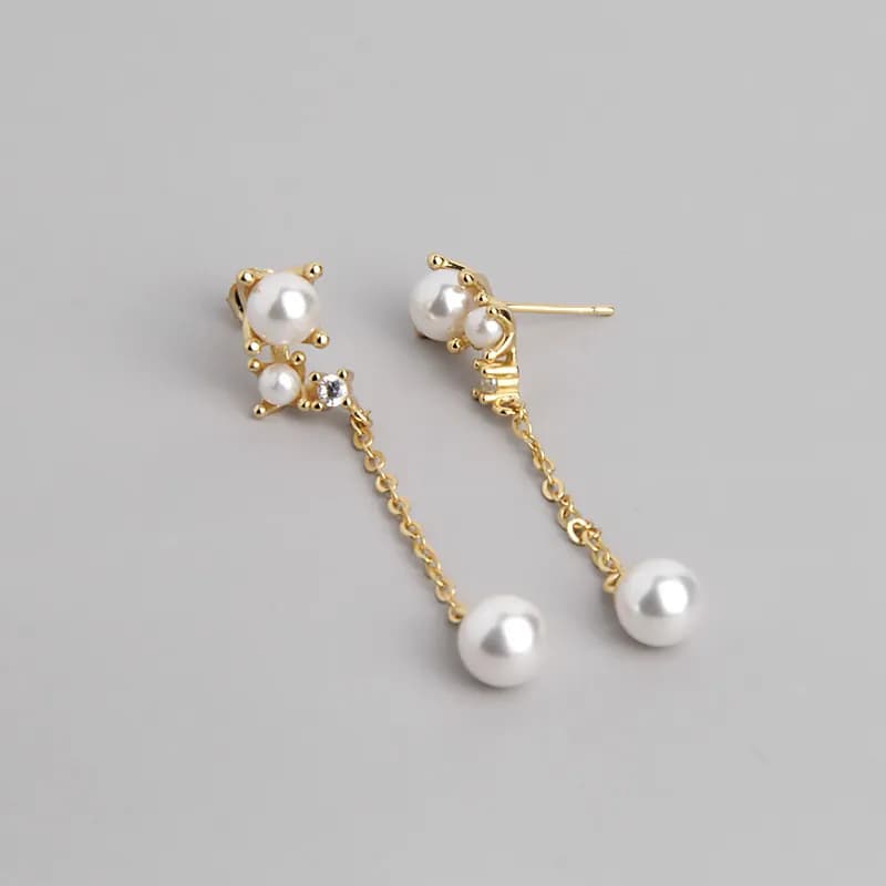 Close-up of pearl chain drop earrings with a cluster of pearls and a dangling pearl
