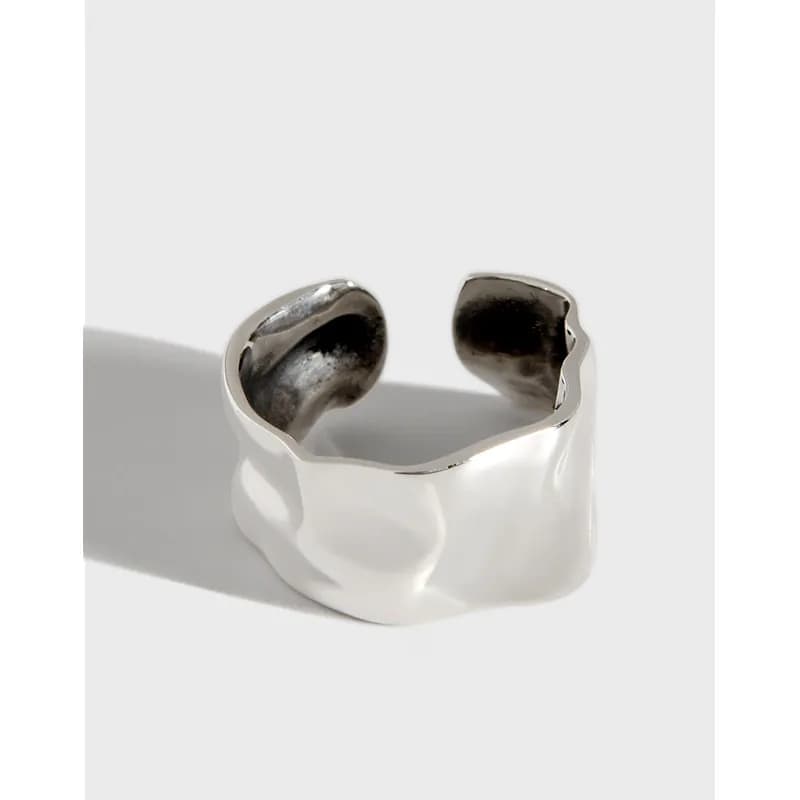 Polished sterling silver wide open-ring with irregular wavy edges.