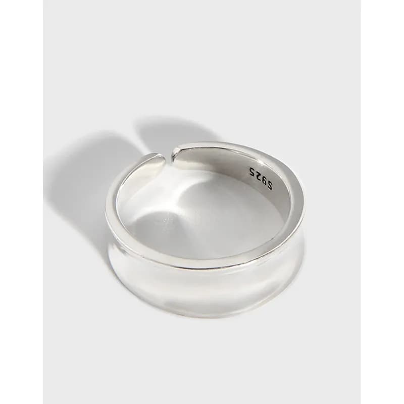 Sterling silver wide band ring with an open gap on a white background.