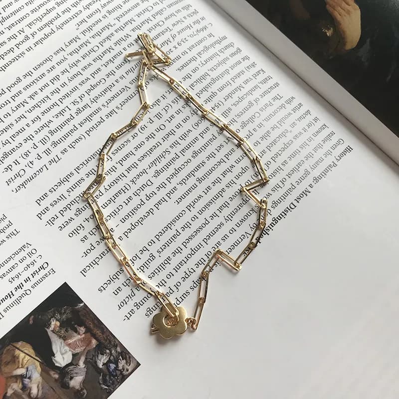 Polished sterling silver geometric bar necklace displayed on a magazine page