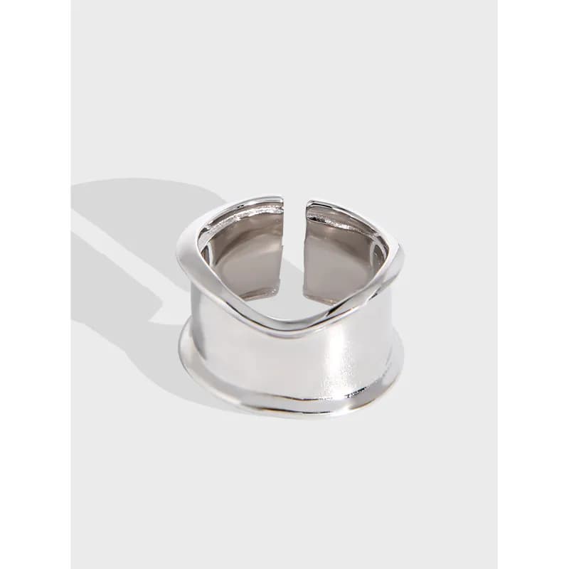 Close-up of a polished sterling silver open cuff ring with a wide curved band and top gap.