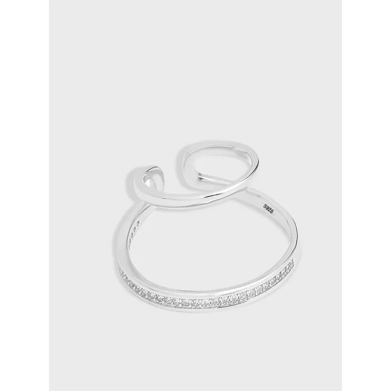 Polished sterling silver intertwined curve earring with pavé detail and open design.