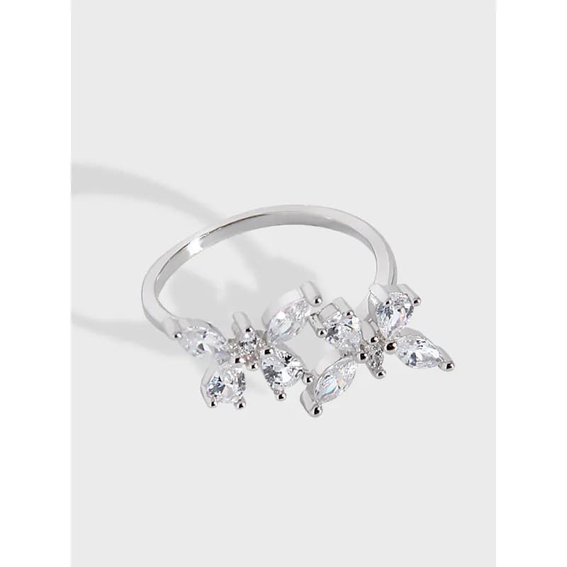 Polished sterling silver ring with three small crystal floral clusters along the band.