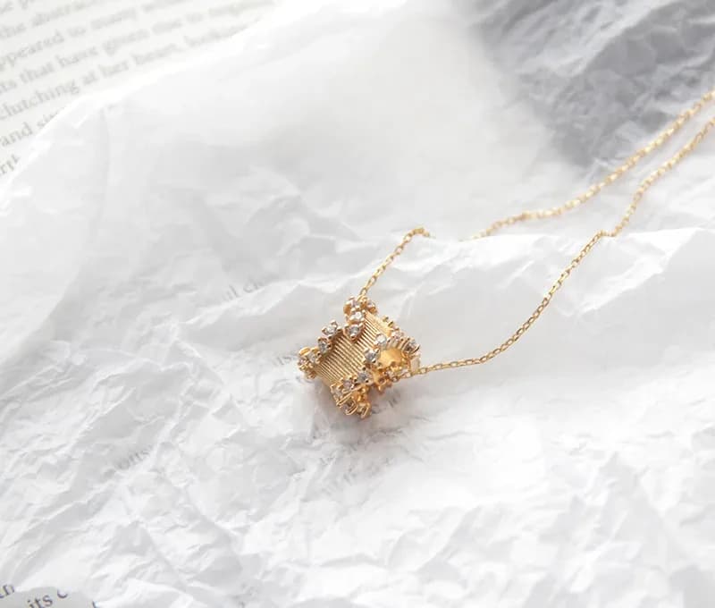 Delicate sterling silver necklace with a small ribbed square pendant set with pavé stones on a fine chain.