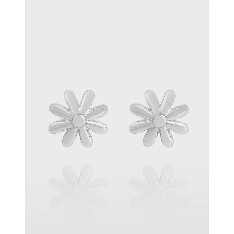 Polished sterling silver daisy petal stud earrings laid side by side on a pale background.
