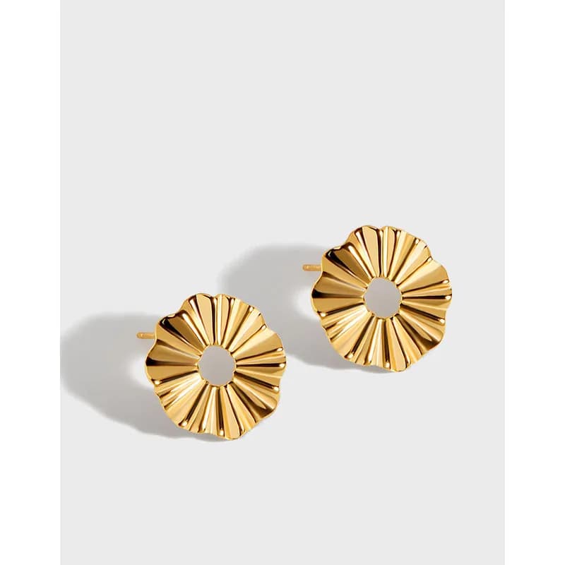 Gold-tone sunburst circular earrings with an open center and posts on a light background.