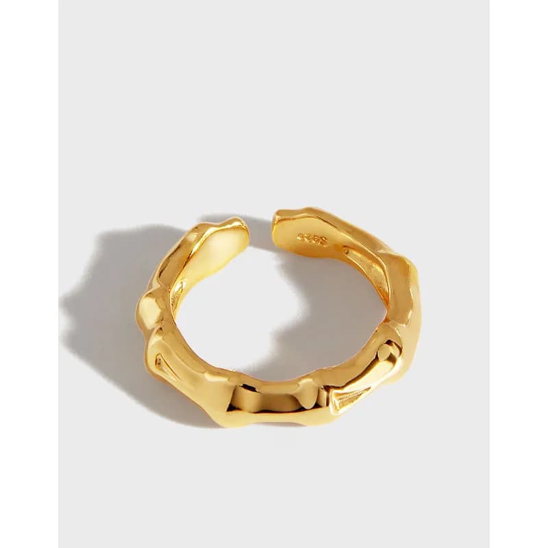 Polished gold-tone chunky link ring with a sculpted, irregular band on a white background.