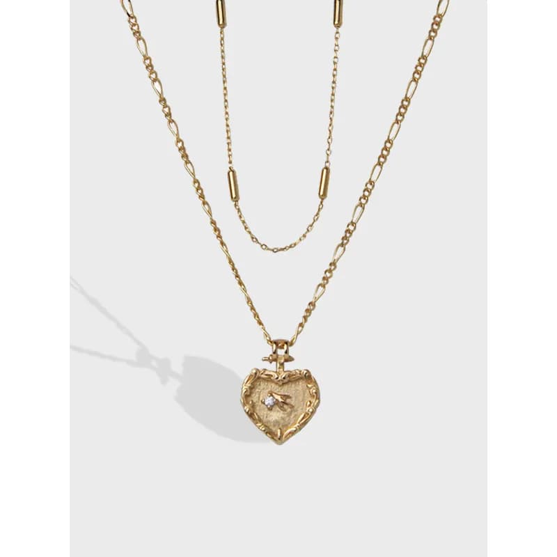 Polished sterling silver layered necklace with a heart pendant and small gemstone