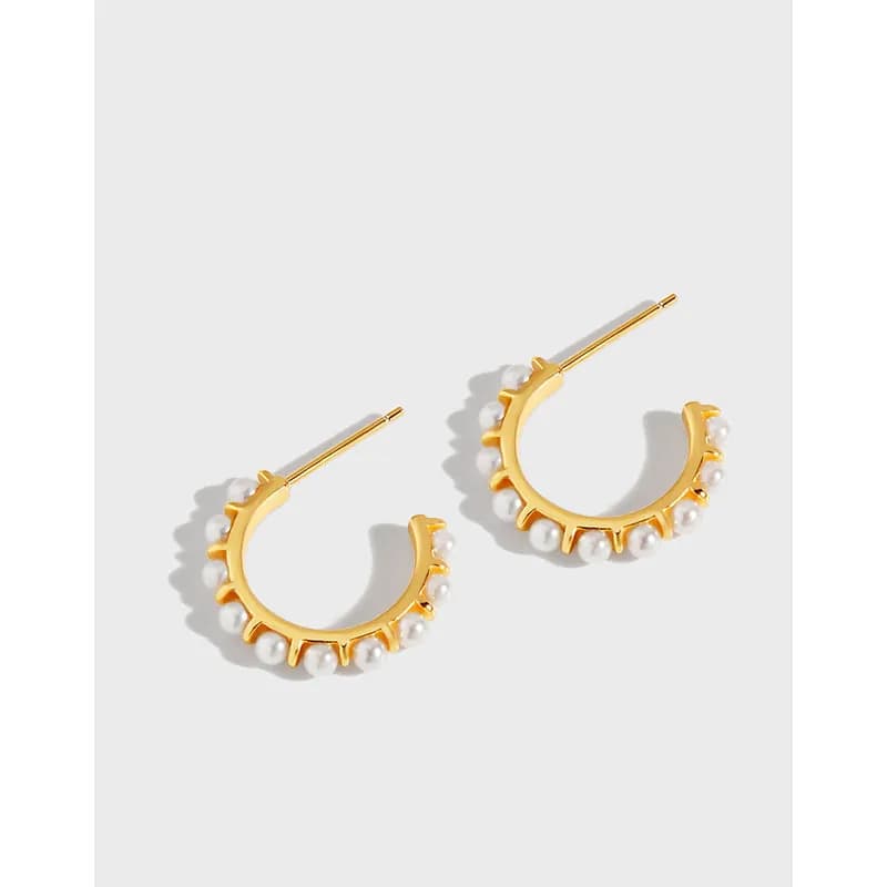 Gold-tone crescent hoop earrings with white bead accents along the outer edge and straight posts