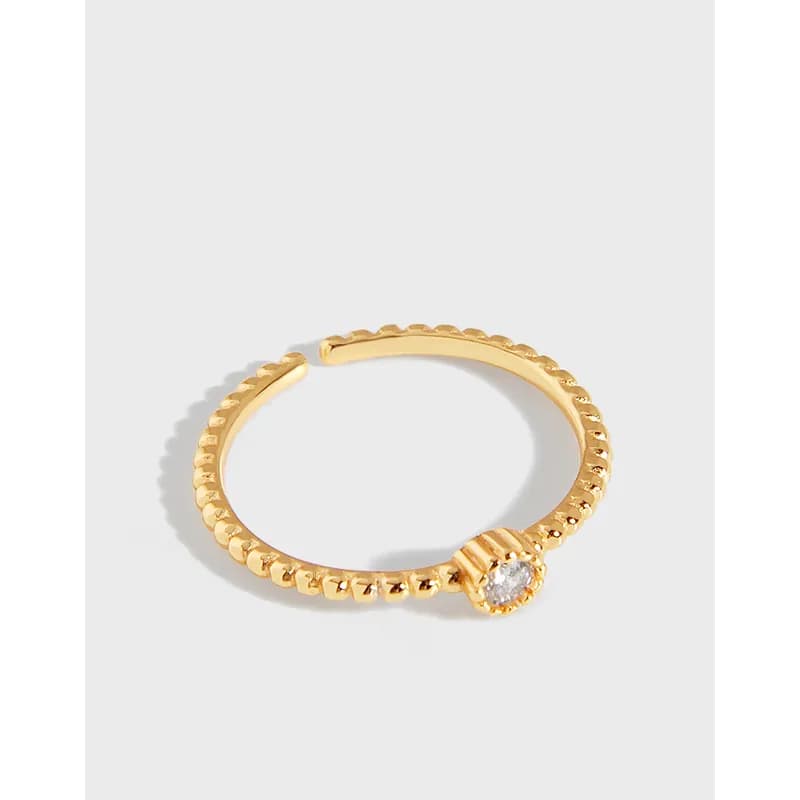 Polished beaded ring with a small crystal bezel-set stone