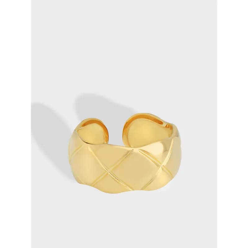 Polished silver open-ring with a quilted diamond pattern on a light background.