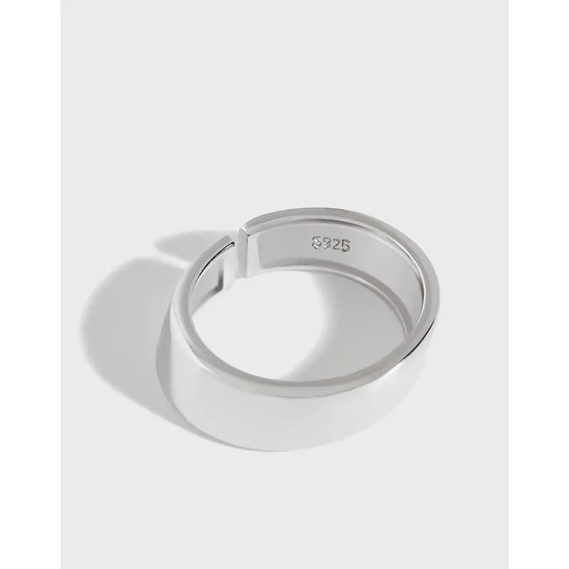 Polished sterling silver wide band ring with a sculpted block profile on a light background.