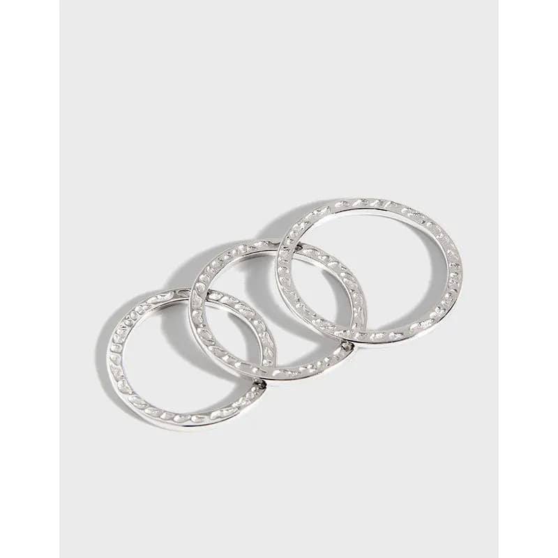 Three interconnected sterling silver rings with small stones around the edge forming a linked cluster.