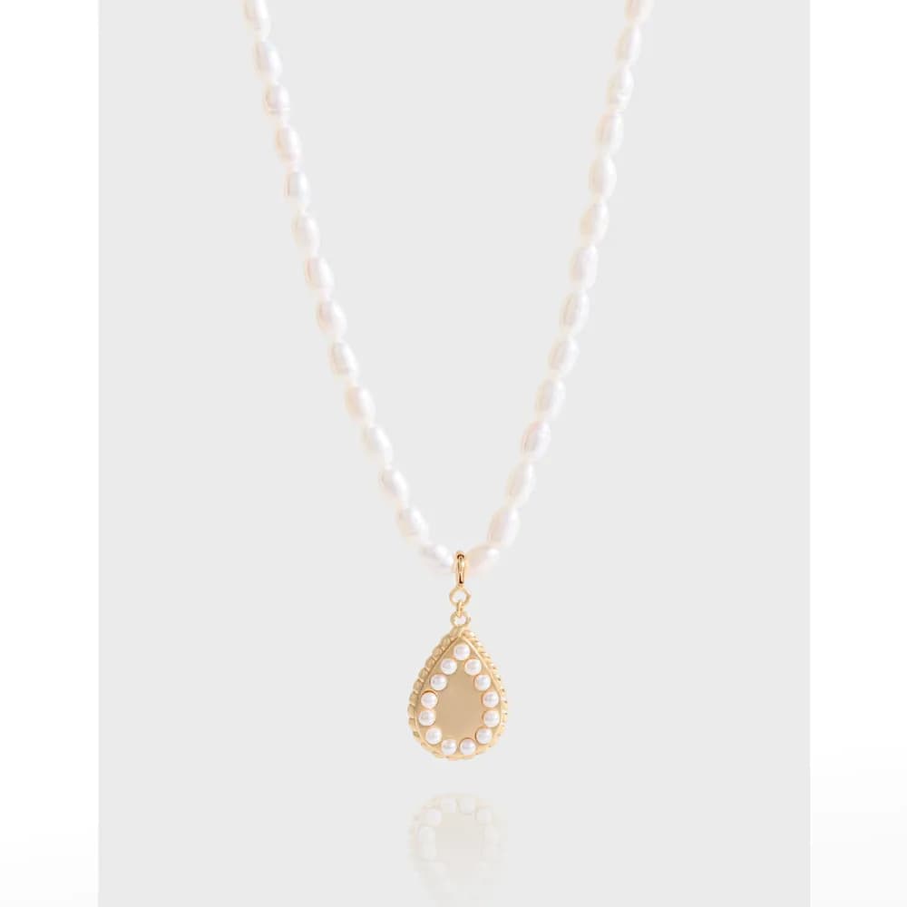 Pearl teardrop pendant necklace with pearl-studded bezel on a beaded strand