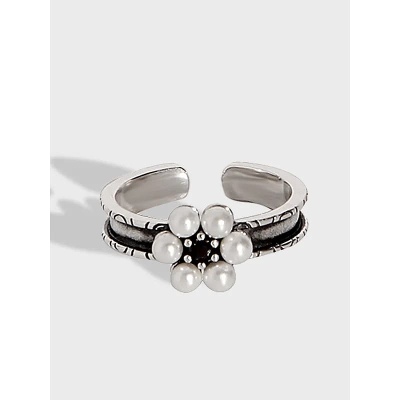 Open silver ring with a pearl flower cluster centerpiece on a polished band.