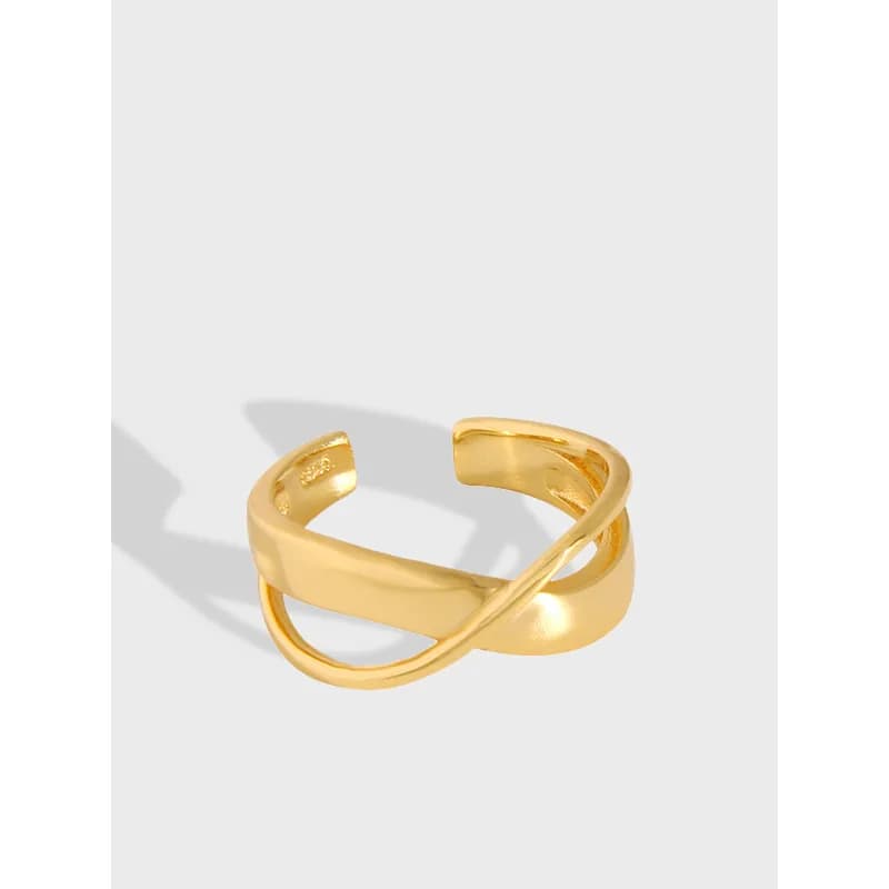 Polished sterling silver open crossover ring with two entwined bands on a light background.