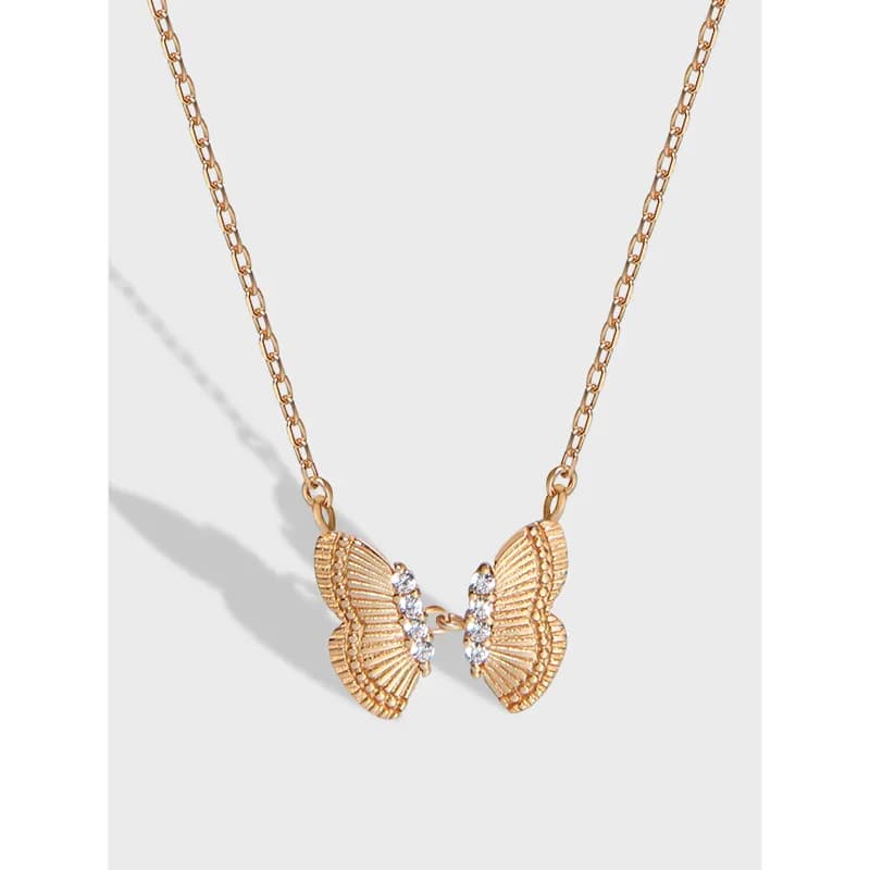Polished gold-tone butterfly split pendant on a delicate chain with crystal accents