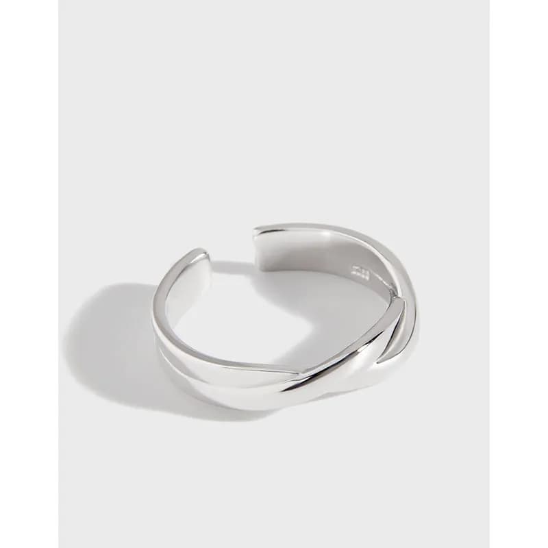 Polished sterling silver open ring with overlapping curved ends and a twisted crossover design.