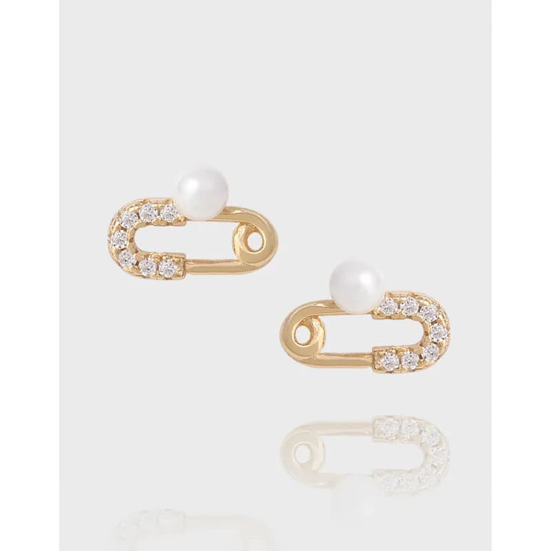 Gold-tone safety-pin shaped earrings with crystal embellishments and a pearl on top