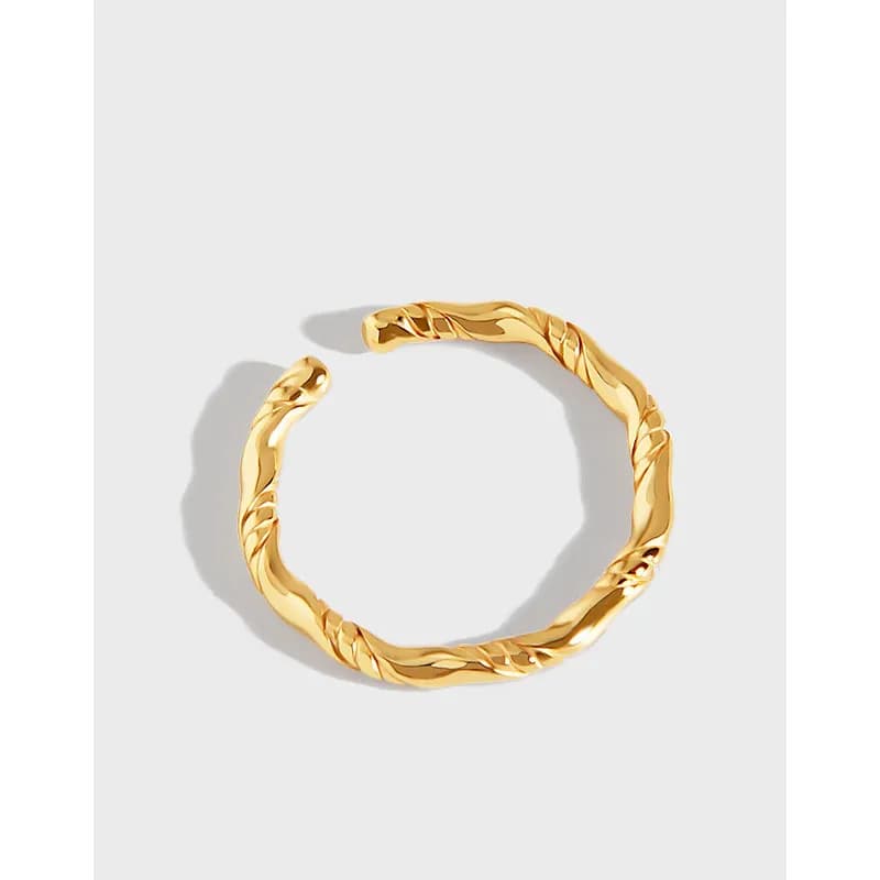 Polished twisted rope ring with an open gap on a light background